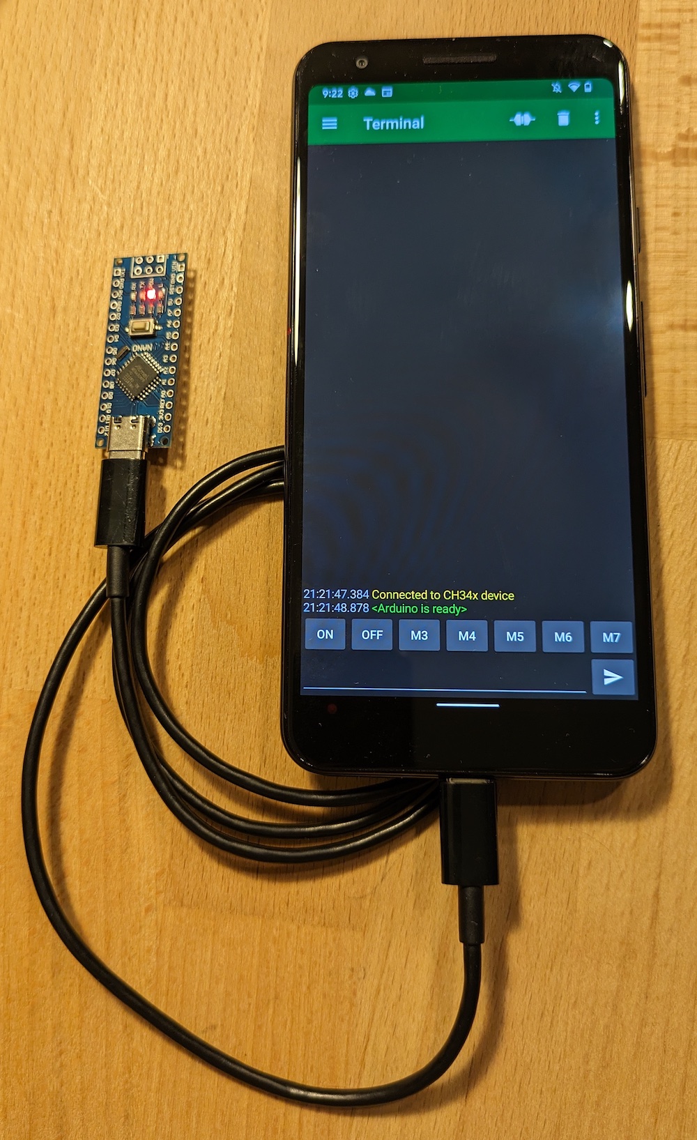 An Android phone with an _Arduino Nano_ connected to its USB port.